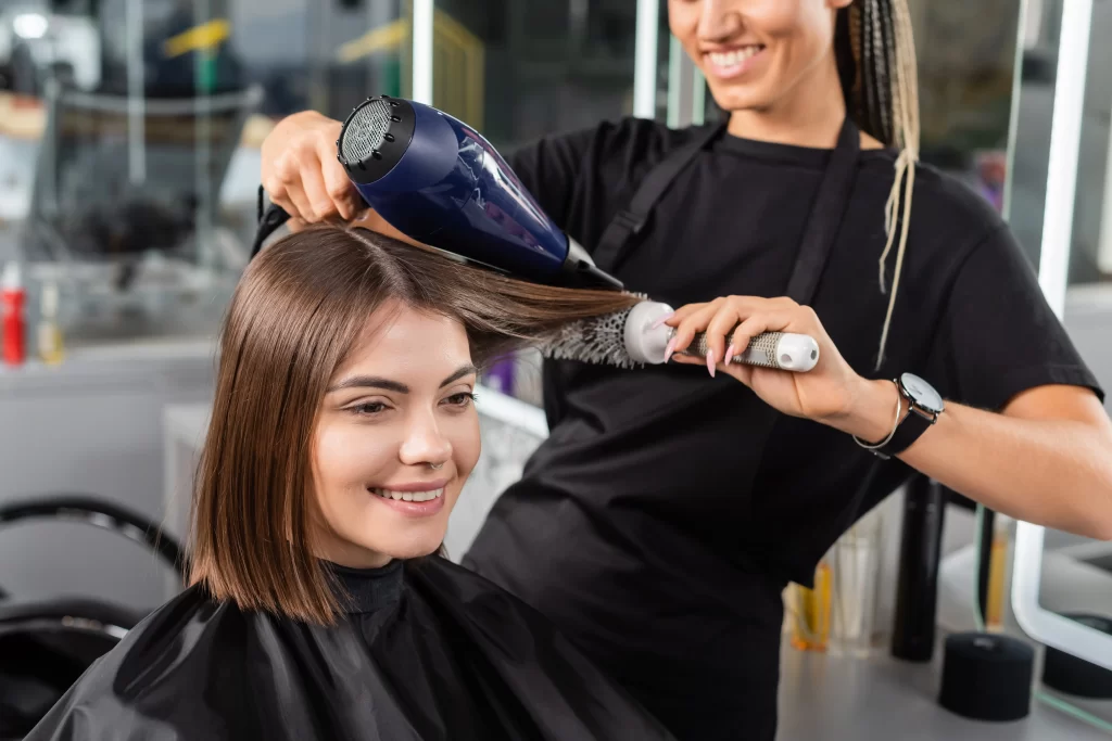 hairstylist blow drying someones hair